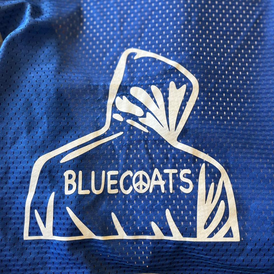 Blue Coats Logo printed on the back of their blue vest uniforms