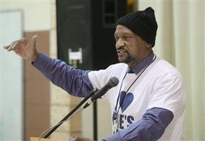 Daryl Craig giving a presentation on stage at one of Erie's public schools